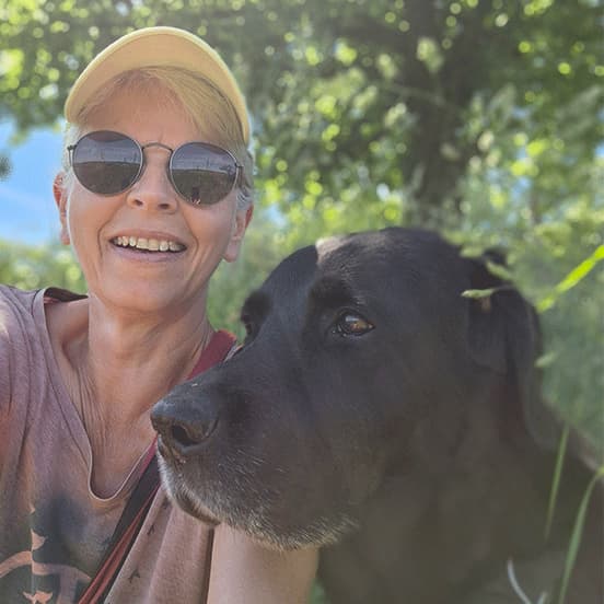 Ich mit meinem Hund (Labrador Retriever, schwarz) unter einem Kirschbaum, und die Vielfalt der Natur genießen